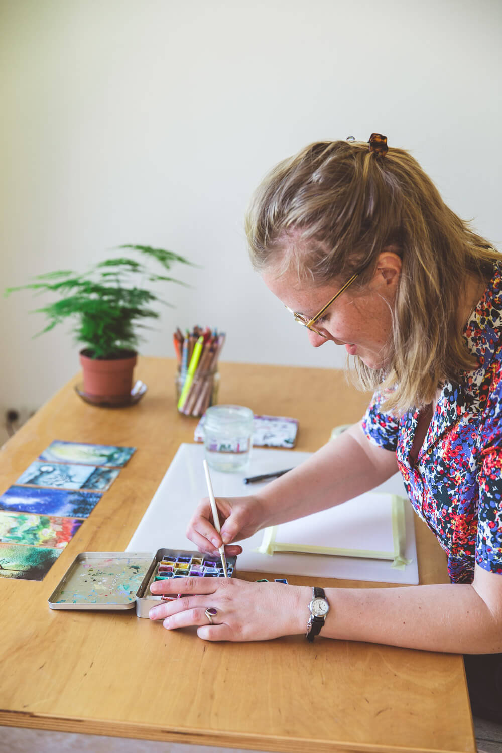 Marina tekent aan tafel met een plantje in de achtergrond